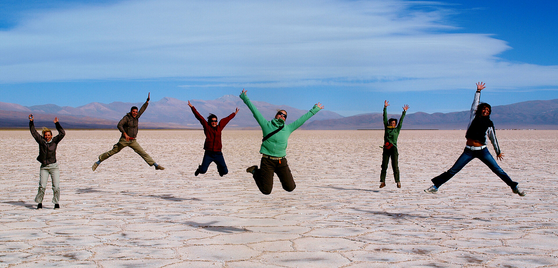 Menschen machen Luftsprung in Wüstenlandschaft