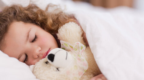 Schlafendes Kind mit Teddy
