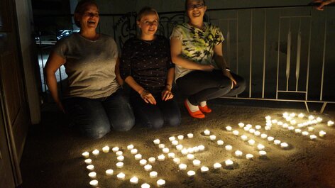 Kerzen Wort Rheuma junge Frauen sitzen auf dem Boden