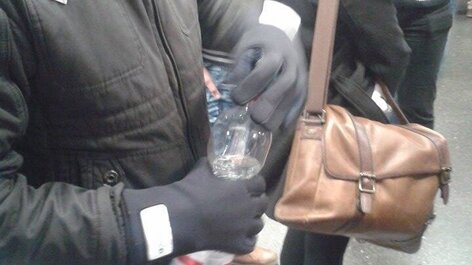 Mann mit Rheumahandschuh öffnet Wasserflasche