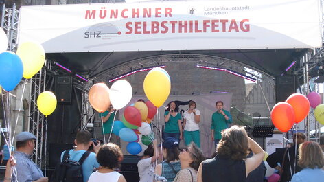 Menschen auf Bühne, Luftballons